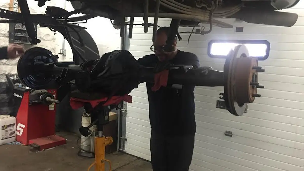Technician with the rear axle out of a Dodge truck at our West Springfield shop