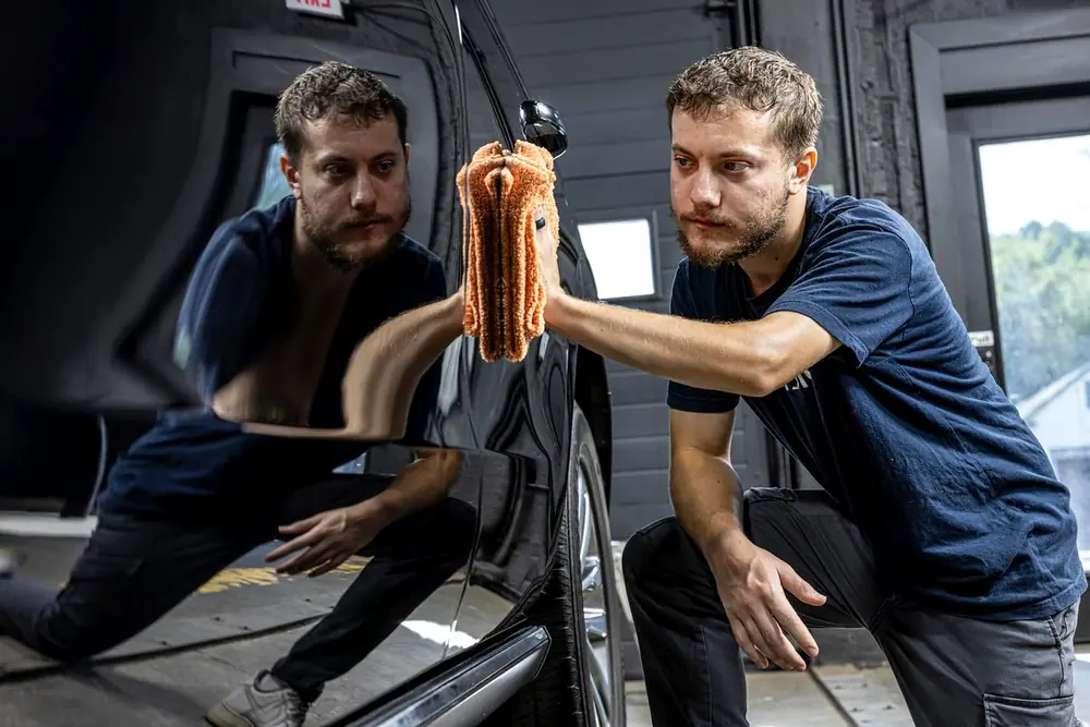 Technician wiping a detailed car