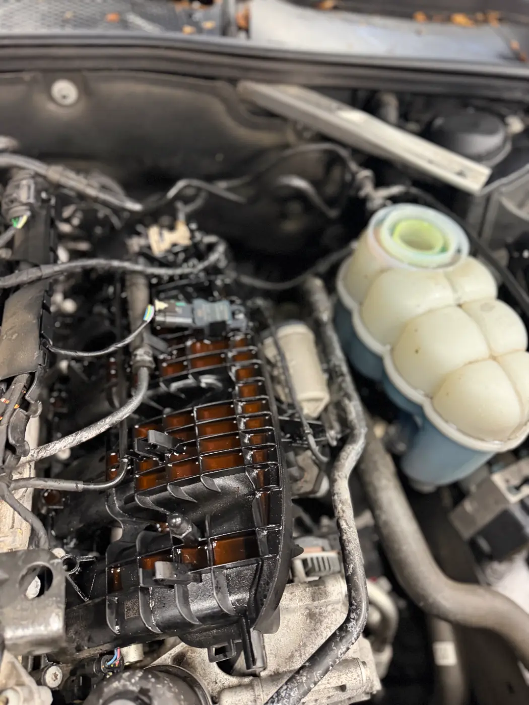 Audi engine bay with the old coolant lines on top of the engine, before the repair at our South Windsor shop